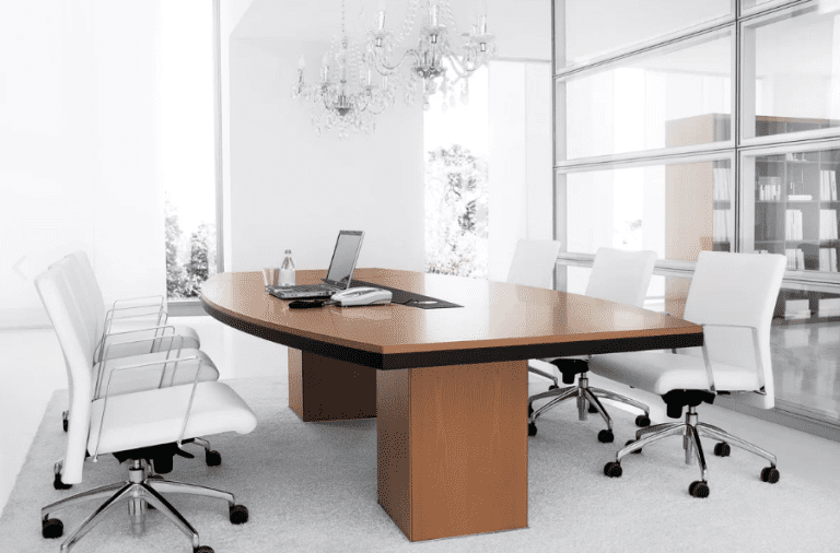 Wooden meeting table with white chairs