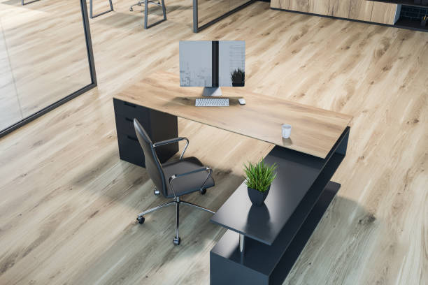 Top view of modern manager office interior with a wooden floor, glass walls, and a stylish computer desk. 3d rendering mock up