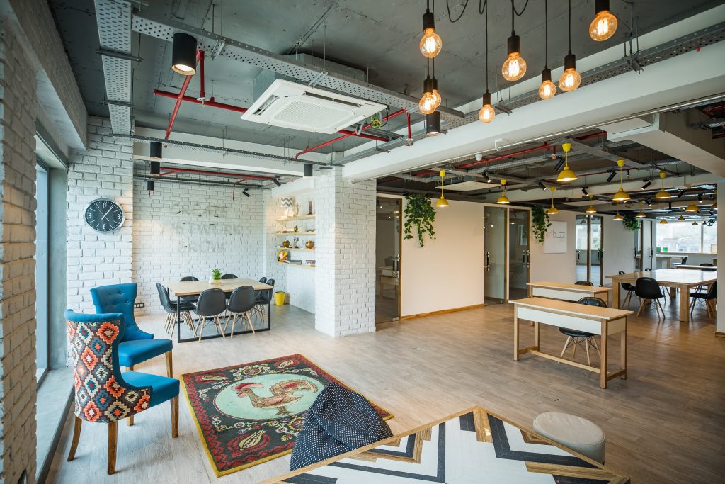 Wooden flooring with rugs and furniture, giving modern workplace aesthetics